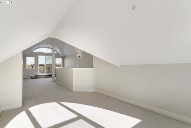 additional living space with vaulted ceiling and light colored carpet