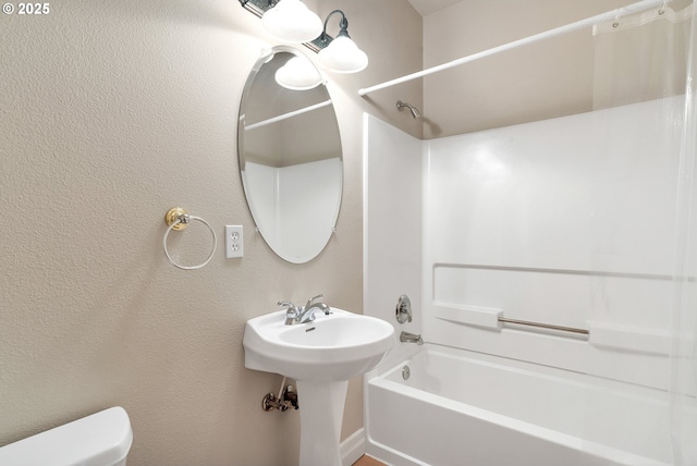 bathroom featuring shower / tub combination and toilet