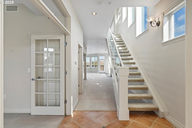 staircase with french doors, carpet, and a wealth of natural light