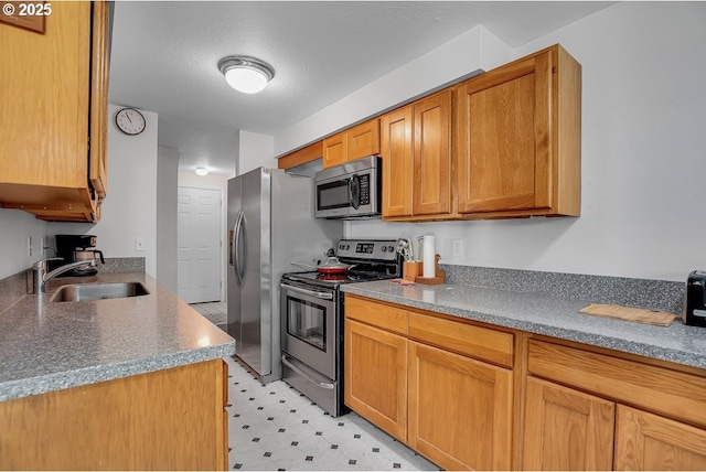 8458 SW Mohawk St, Tualatin, OR 97062 - kitchen featuring stainless steel appliances, a sink, light flooring, and brown cabinetry