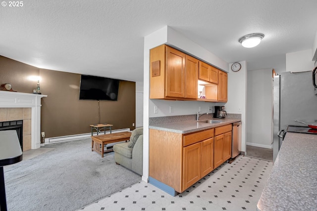 8458 SW Mohawk St, Tualatin, OR 97062 - kitchen with a textured ceiling, appliances with stainless steel finishes, open floor plan, a tile fireplace, and a sink