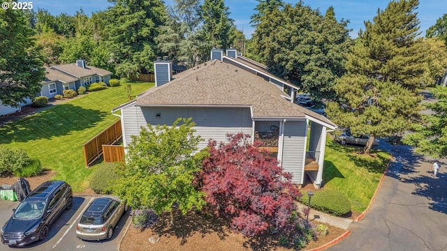 8458 SW Mohawk St, Tualatin, OR 97062 - view of side of property featuring roof with shingles, uncovered parking, a chimney, and a yard