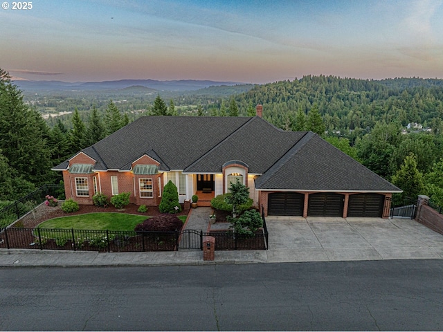 1500 SW Miller Ct, Gresham, OR 97080 - view of front of property featuring a wooded view, a fenced front yard, concrete driveway, and a garage