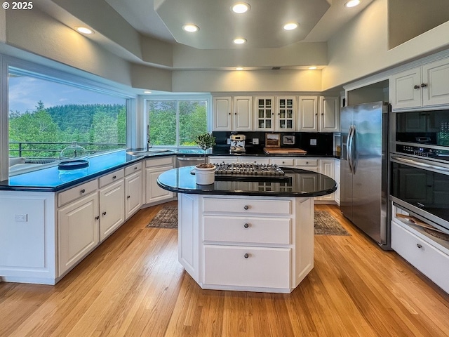 1500 SW Miller Ct, Gresham, OR 97080 - kitchen with appliances with stainless steel finishes, a center island, dark countertops, a sink, and white cabinetry