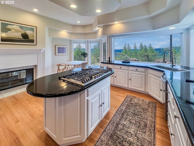 1500 SW Miller Ct, Gresham, OR 97080 - kitchen featuring stainless steel gas cooktop, white cabinets, a sink, a center island, and dark countertops
