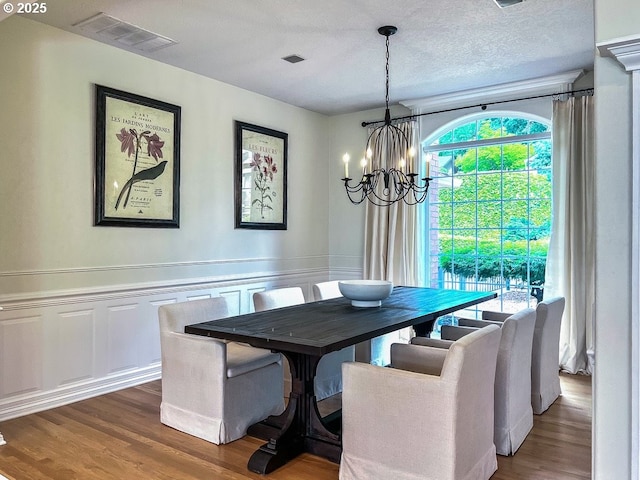 1500 SW Miller Ct, Gresham, OR 97080 - dining area featuring a chandelier, wood finished floors, a decorative wall, and a wainscoted wall