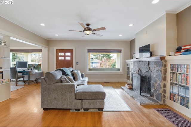 living room featuring plenty of natural light, a fireplace, and light hardwood / wood-style floors