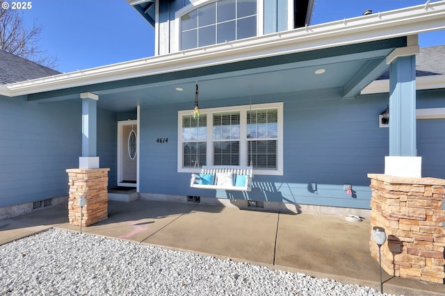 view of exterior entry featuring covered porch