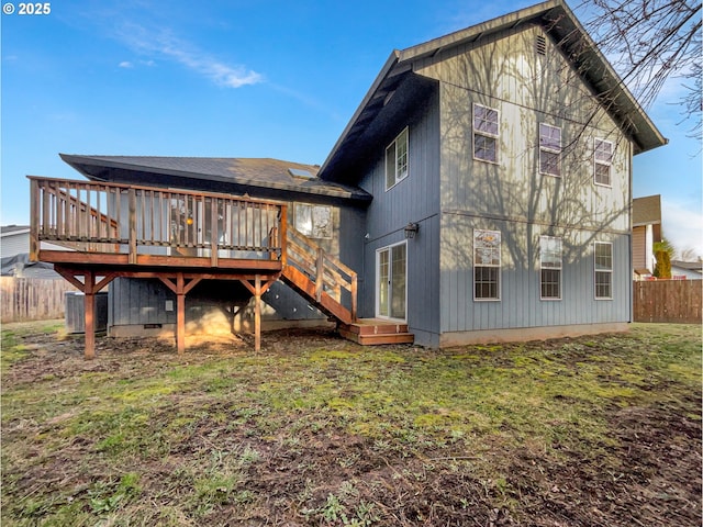 back of house featuring a lawn, fence, central AC, and a wooden deck