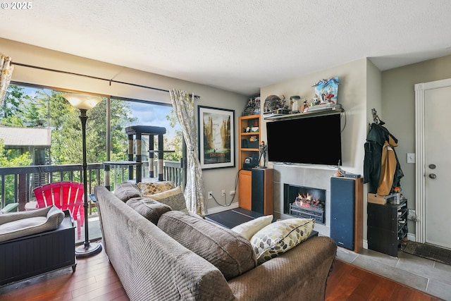 7522 SW Barnes Rd Unit E, Portland, OR 97225 - living room featuring a textured ceiling, wood-type flooring, and a lit fireplace