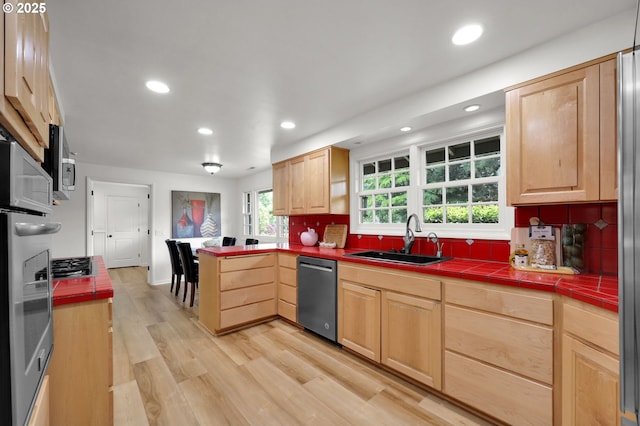 996 Lariat Dr, Eugene, OR 97401 - kitchen with stainless steel appliances, light brown cabinets, a sink, tile counters, and a peninsula
