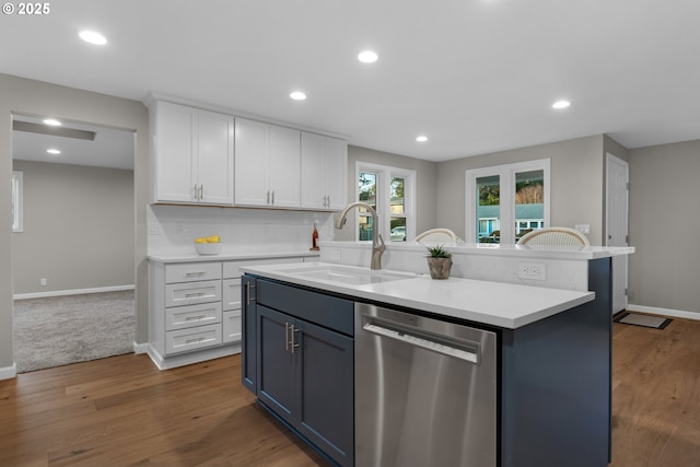 kitchen with white cabinets, a center island, sink, dark hardwood / wood-style floors, and stainless steel dishwasher