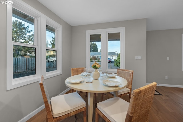 dining space with hardwood / wood-style floors and a healthy amount of sunlight