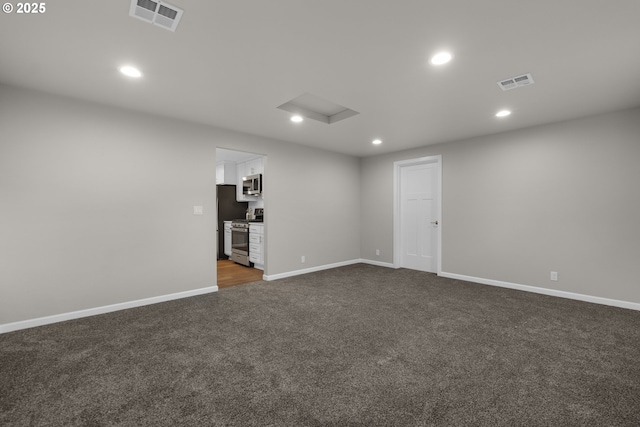 spare room featuring dark colored carpet