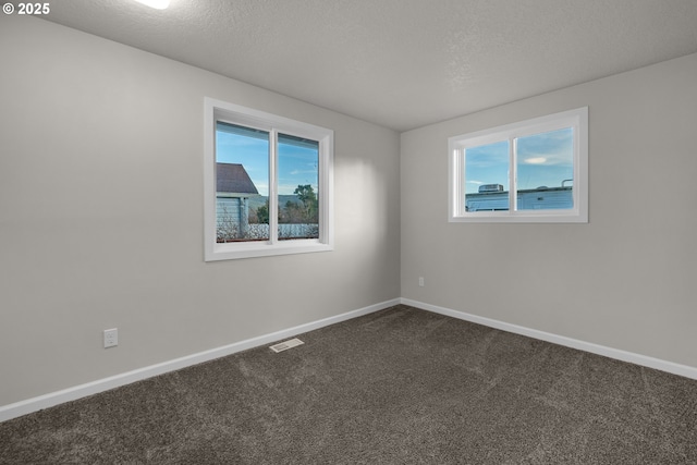 carpeted spare room with a textured ceiling