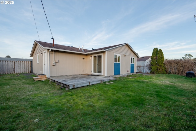 back of property with a deck and a yard