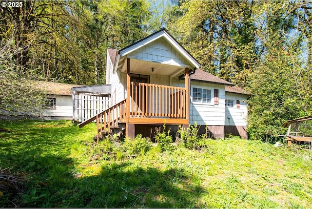 back of property with a yard and stairs