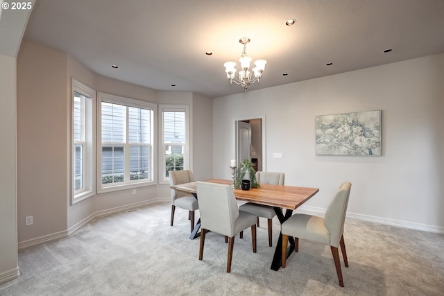 dining area featuring light carpet and an inviting chandelier