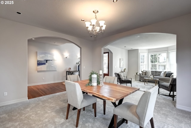 carpeted dining space with a chandelier