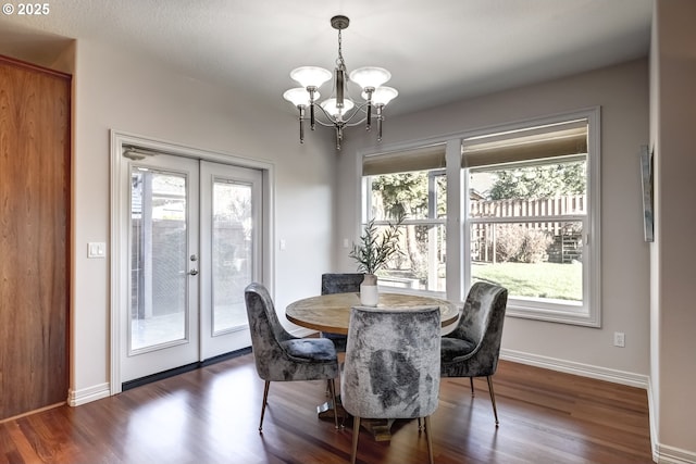 dining area with french doors, dark hardwood / wood-style flooring, and an inviting chandelier