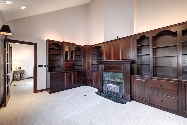 office with light carpet, a high end fireplace, and high vaulted ceiling