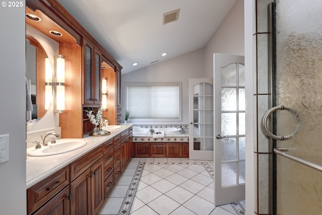 bathroom featuring lofted ceiling, vanity, tile patterned floors, and a bathing tub