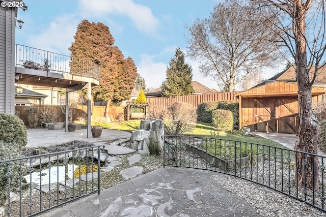 view of patio featuring a balcony and a shed