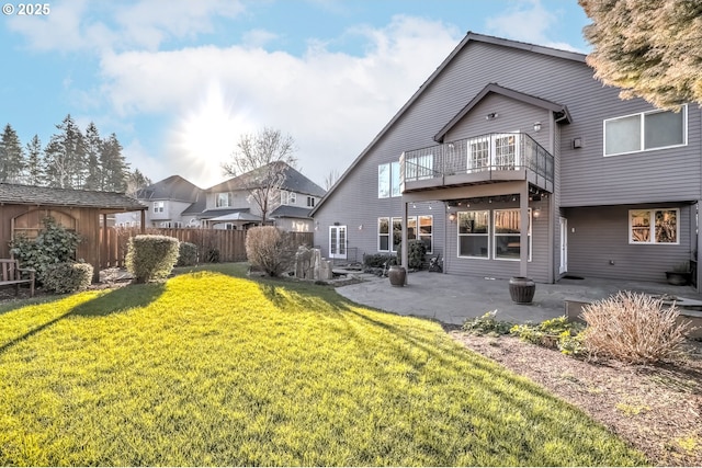 back of house with a patio, a yard, and a storage shed