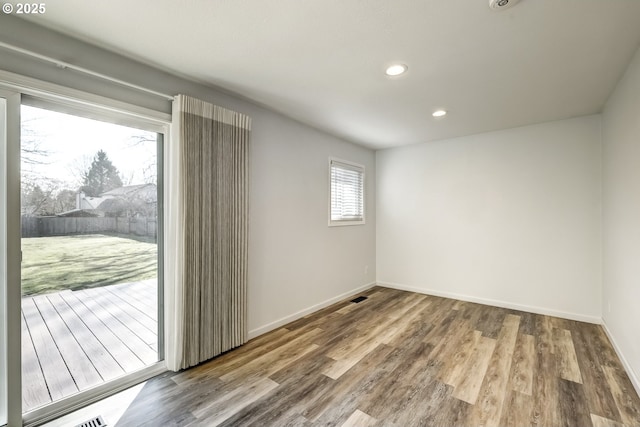 unfurnished room featuring visible vents, recessed lighting, wood finished floors, and baseboards