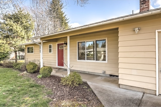 doorway to property with a lawn