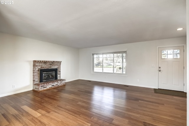 unfurnished living room featuring wood finished floors and baseboards