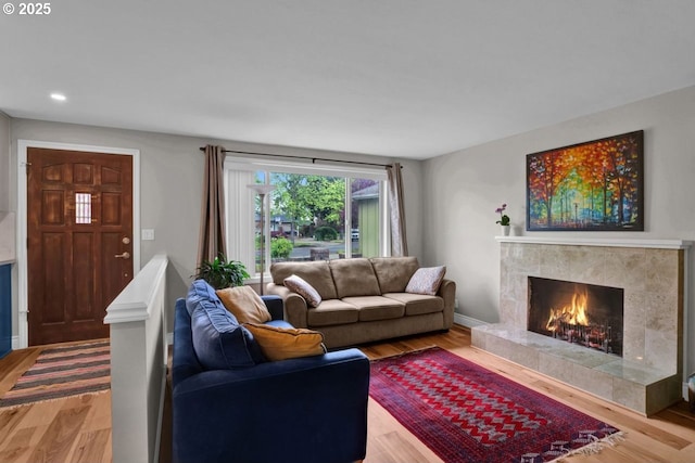 living area with a premium fireplace, recessed lighting, and wood finished floors