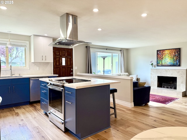 kitchen featuring a sink, light countertops, blue cabinetry, stainless steel appliances, and island range hood