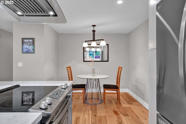 dining space featuring light wood-style floors, recessed lighting, and baseboards