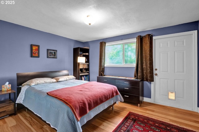 bedroom featuring baseboards and light wood-style flooring