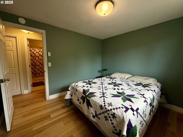bedroom featuring baseboards and light wood-style floors
