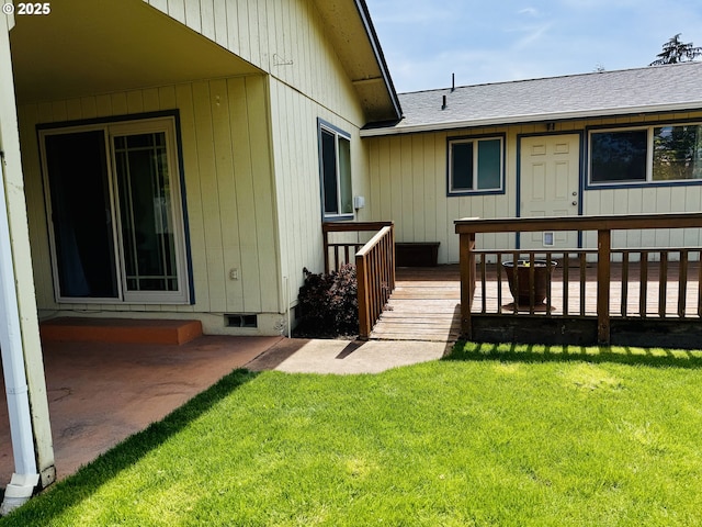 property entrance featuring a yard, a wooden deck, and roof with shingles