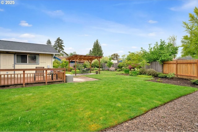 view of yard with a patio, a pergola, a wooden deck, and a fenced backyard