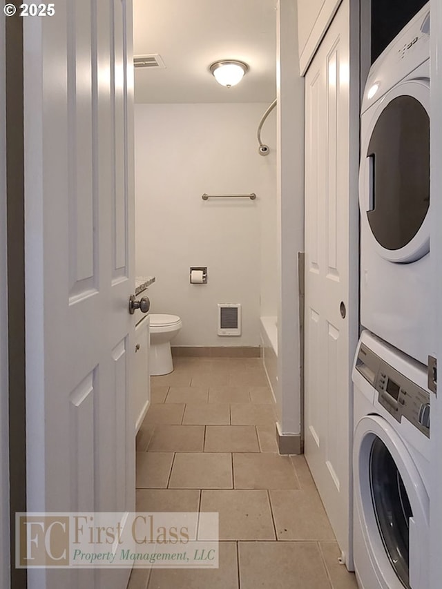 5516 NE Hoyt St, Portland, OR 97213 - washroom with stacked washer and clothes dryer, light tile patterned flooring, and heating unit