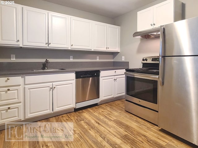 5516 NE Hoyt St, Portland, OR 97213 - kitchen featuring stainless steel appliances, under cabinet range hood, dark countertops, and white cabinets