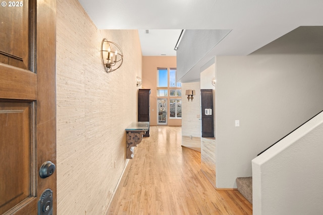 hallway featuring light hardwood / wood-style floors and an inviting chandelier