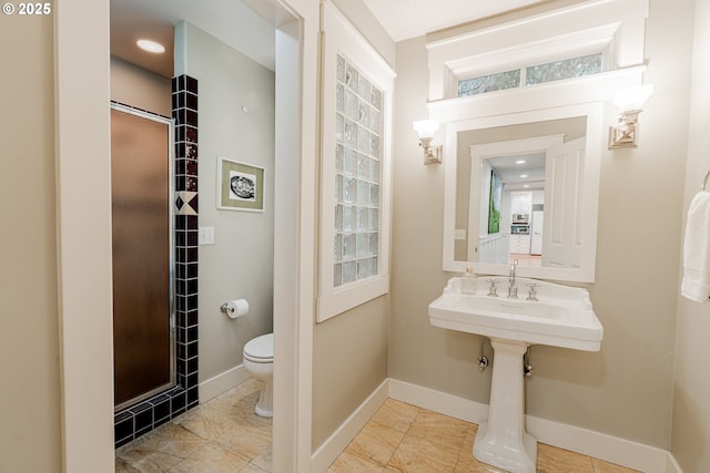 bathroom featuring baseboards and toilet