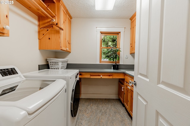 laundry room with separate washer and dryer, cabinet space, and a textured ceiling