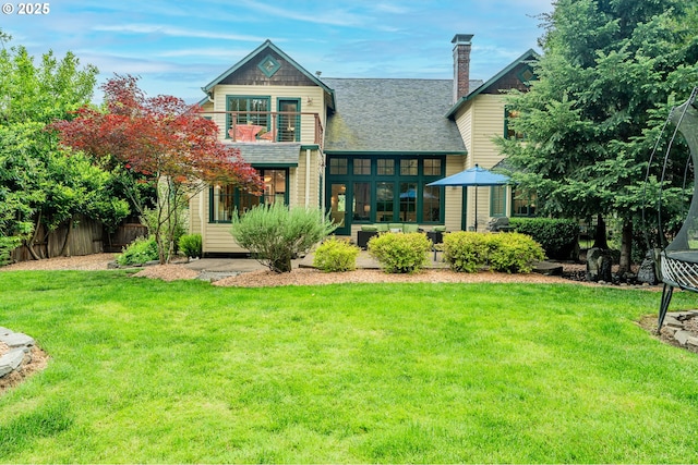 back of property featuring roof with shingles, a balcony, and a chimney