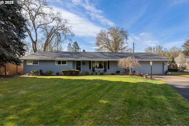 ranch-style home with a garage, driveway, fence, and a front lawn