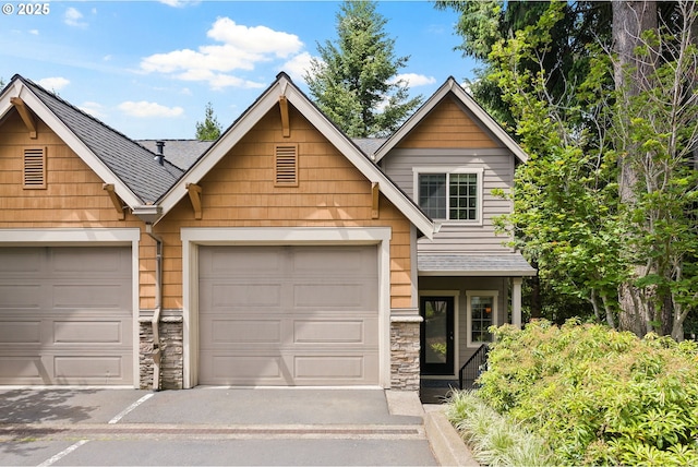 12842 Boones Ferry Rd, Lake Oswego, OR 97035 - view of front facade featuring stone siding, a shingled roof, an attached garage, and driveway