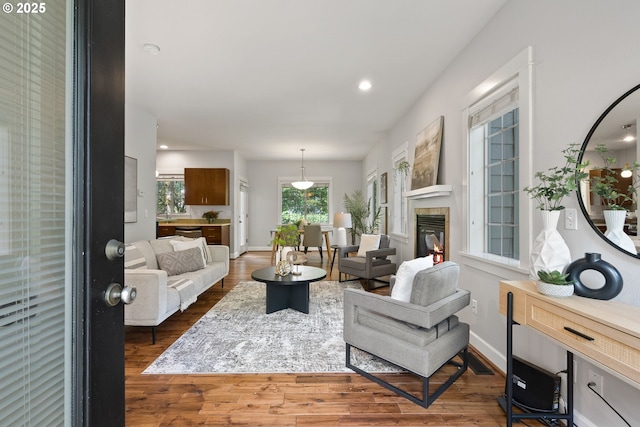 12842 Boones Ferry Rd, Lake Oswego, OR 97035 - living area with wood finished floors, a tiled fireplace, recessed lighting, and baseboards
