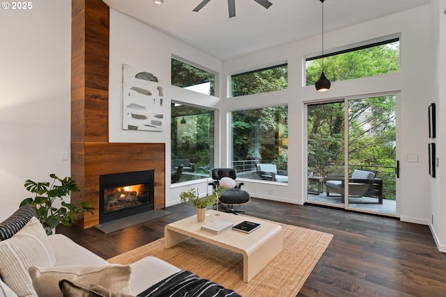 5210 SW Hewett Blvd, Portland, OR 97221 - living area featuring ceiling fan, a lit fireplace, wood finished floors, and a towering ceiling