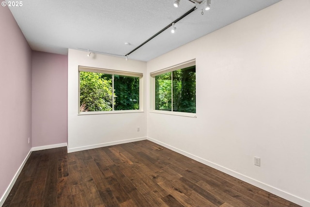 5210 SW Hewett Blvd, Portland, OR 97221 - spare room with rail lighting and dark wood-type flooring