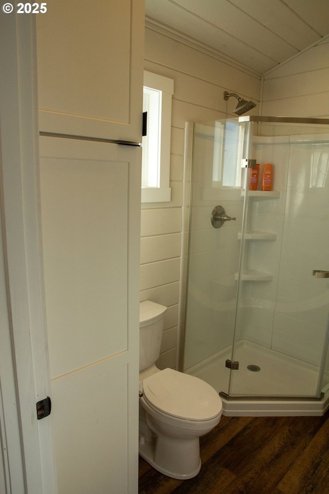 full bath featuring a stall shower, crown molding, toilet, and wood finished floors